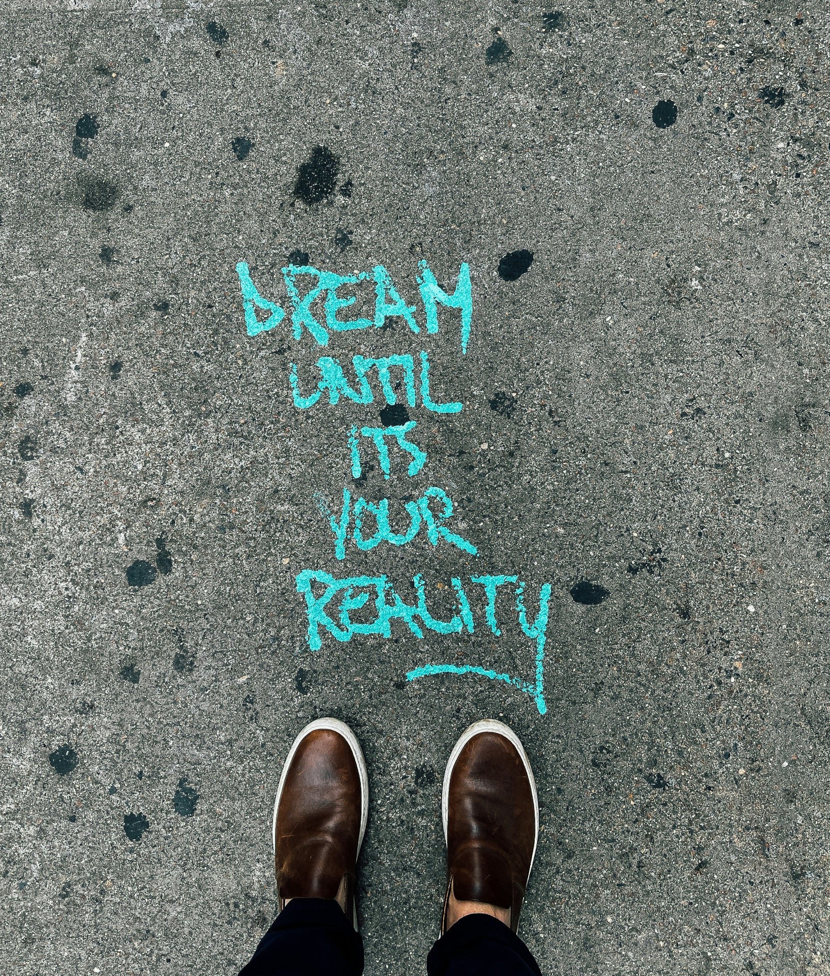 Tekst op de grond aangebracht: 'dream ubtil it's your reality'.